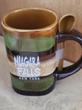 NIAGARA FALLS NEW YORK. GLAZED POTTREY MUG WITH SPOON. NWT. GREEN BROWN